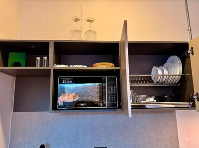 a microwave oven in a kitchen with plates and dishes at Estrena Apartamento, Avenida Santander, Edificio BREAK in Manizales