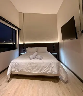 a bedroom with a bed with two towels on it at Estrena Apartamento, Avenida Santander, Edificio BREAK in Manizales