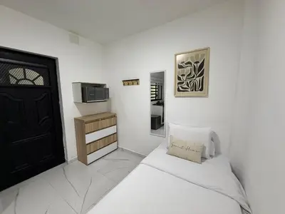 a white room with a bed and a black door at Casa Bendita - Apto 101 in Medellín