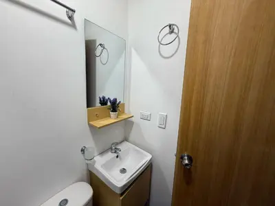 a bathroom with a toilet and a sink and a mirror at Casa Bendita - Apto 101 in Medellín