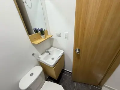 a bathroom with a toilet and a sink and a mirror at Casa Bendita - Apto 101 in Medellín