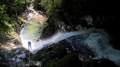 a man standing in front of a waterfall at Cabanas ecologicas con vista espectacular y cascada privada - Finca Qawana Ecolodge en San Carlos