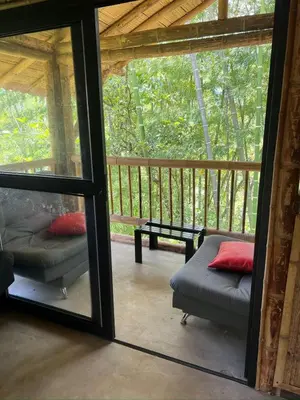 a screened in porch with a couch and a table at Vip cabaña vista verde in Cocorná