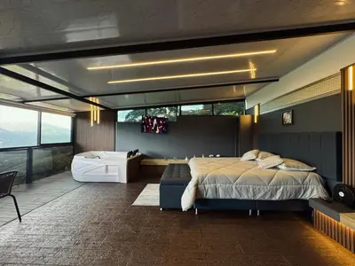 a bedroom with a bed and a tub and a television at Altos del Silencio in San Rafael