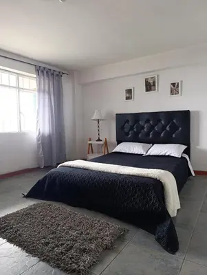 a bedroom with a large bed with a black headboard at Casa Acogedora en Ubicación Estrategica in Manizales