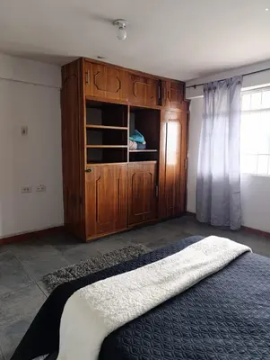 a bedroom with a bed and a wooden cabinet at Casa Acogedora en Ubicación Estrategica in Manizales