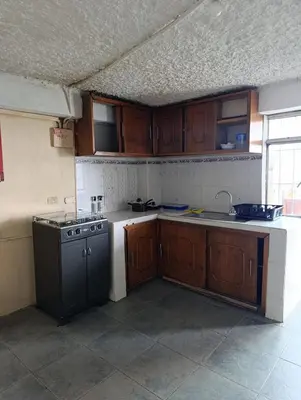 a kitchen with wooden cabinets and a sink and a stove at Casa Acogedora en Ubicación Estrategica in Manizales