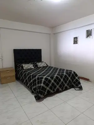 a bedroom with a bed with a checkered blanket at Casa Acogedora en Ubicación Estrategica in Manizales