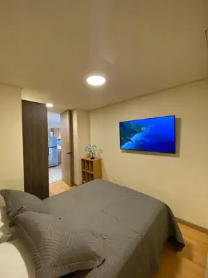 a bedroom with a bed with a television on the wall at San Telmo Apartment with Jacuzzy in Guatapé