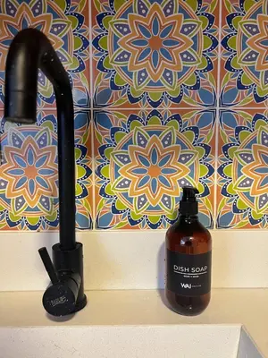a bottle of dish soap next to a bathroom sink at Acogedor en parque principal Guatape con Jacuzzi in Guatapé