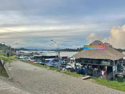 a building with a straw roof next to a marina at Acogedor en parque principal Guatape con Jacuzzi in Guatapé