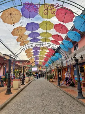 a shopping mall with umbrellas hanging from the ceiling at Acogedor en parque principal Guatape con Jacuzzi in Guatapé