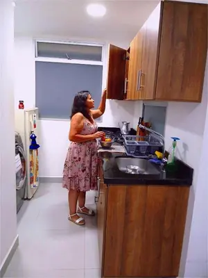 a woman standing in a kitchen preparing food at Apartment 202 Garden Shelter - 10 min to Balandú Park in Jardin