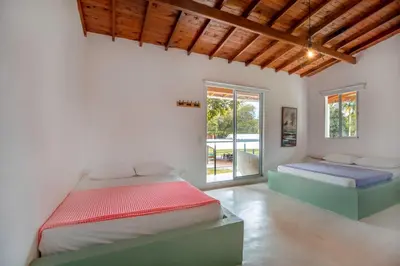 a bedroom with two beds and a window at Fina Hotel La Morenita in Santa Fe de Antioquia