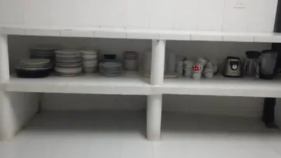 a white shelf with plates and cups on it at Fina Hotel La Morenita in Santa Fe de Antioquia