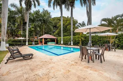 a pool with chairs and a table and umbrella at Fina Hotel La Morenita in Santa Fe de Antioquia