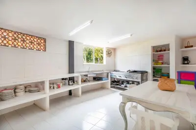 a large white kitchen with a table and a sink at Fina Hotel La Morenita in Santa Fe de Antioquia