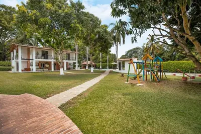 a yard with a playground and a house at Fina Hotel La Morenita in Santa Fe de Antioquia