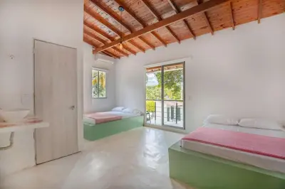 a bedroom with two beds and a window at Fina Hotel La Morenita in Santa Fe de Antioquia