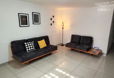 a living room with two black couches and a lamp at Casa Linda Zona Rosa Buenos Aires, Natural Garden in Medellín
