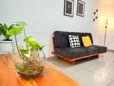 a living room with a couch and a vase on a table at Casa Linda Zona Rosa Buenos Aires, Natural Garden in Medellín