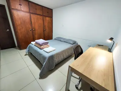 a small bedroom with a bed and a wooden cabinet at Casa Linda Zona Rosa Buenos Aires, Natural Garden in Medellín