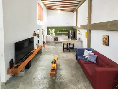 a living room with a red couch and a kitchen at Modern Loft in Zona Rosa Buenos Aires WiFi 500Mb in Medellín