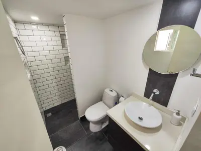 a bathroom with a toilet and a sink and a mirror at Modern Loft in Zona Rosa Buenos Aires WiFi 500Mb in Medellín