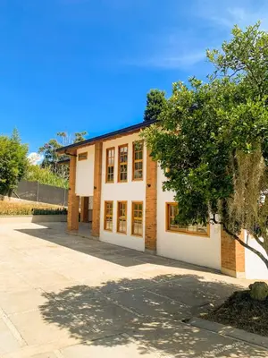 a brick building with a tree in front of it at AMAZING EL POBLADO VIEWs-MODERN VILLA in Envigado