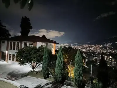 a building with a view of a city at night at AMAZING EL POBLADO VIEWs-MODERN VILLA in Envigado