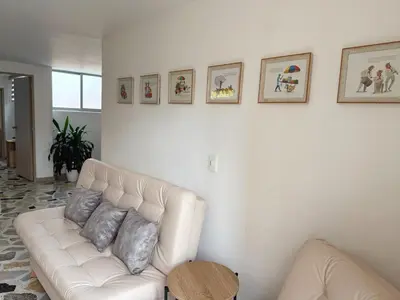 a white couch in a living room with pictures on the wall at Apartamento para 5 personas en Laureles, Estadio in Estación El Salto