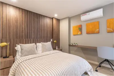 a bedroom with a bed with a wooden headboard at Manila Luxury Suites 301 in Medellín