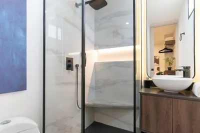 a bathroom with a glass shower and a sink at Manila Luxury Suites 301 in Medellín