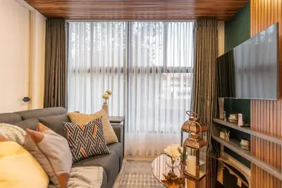 a living room with a couch and a large window at Manila Luxury Suites 301 in Medellín