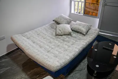 a bed with pillows on it in a room at Casa con vista a la montaña en Manizales in Manizales
