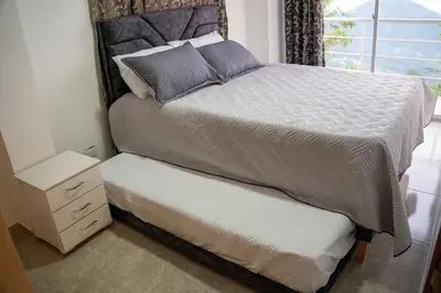 a bedroom with a large bed and a window at Casa con vista a la montaña en Manizales in Manizales