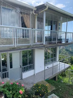 a house with a porch and a balcony at Casa con vista a la montaña en Manizales in Manizales