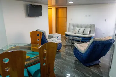 a living room with a glass table and chairs at Casa con vista a la montaña en Manizales in Manizales