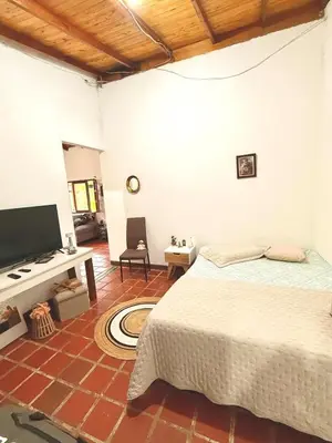a bedroom with a bed and a flat screen tv at Villa Amparo Casa Finca in Rionegro