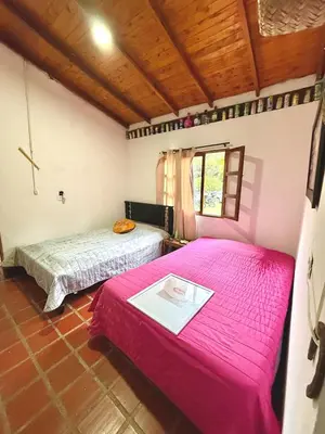 two beds in a room with pink sheets at Villa Amparo Casa Finca in Rionegro