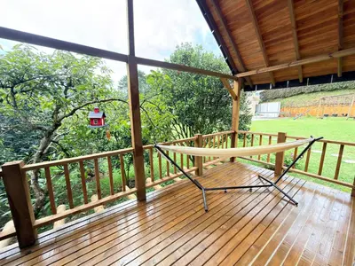 a porch with a bench on a wooden deck at Wooden House in Rionegro