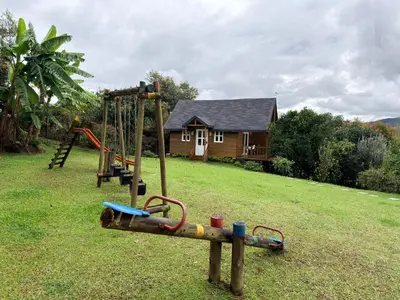 a playground in a yard with a house at Wooden House in Rionegro