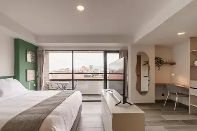 a hotel room with a bed and a large window at Engaging Loft with Balcony in Laureles in Medellín