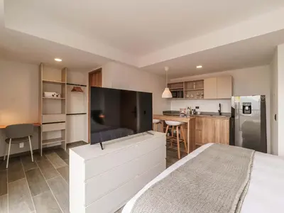 a bedroom with a large television on a white dresser at Engaging Loft with Balcony in Laureles in Medellín