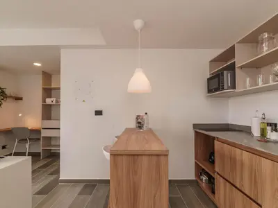 a kitchen with white walls and a wooden counter top at Engaging Loft with Balcony in Laureles in Medellín