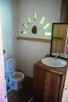 a bathroom with a toilet and a sink and a mirror at Familia Verde Eco Hostal in San Carlos