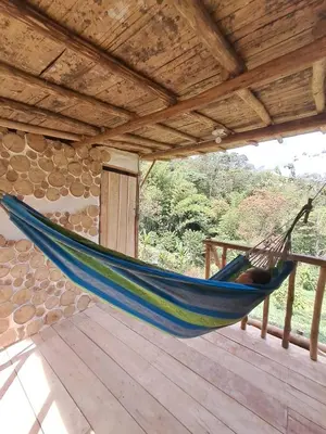 a blue hammock hanging from a roof at Familia Verde Eco Hostal in San Carlos