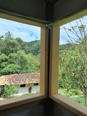 an open window with a view of a house at Familia Verde Eco Hostal in San Carlos