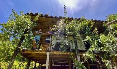 two people standing on the balcony of a tree house at Familia Verde Eco Hostal in San Carlos