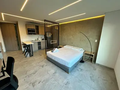 a bedroom with a bed and a kitchen at Apartaestudio in Medellín